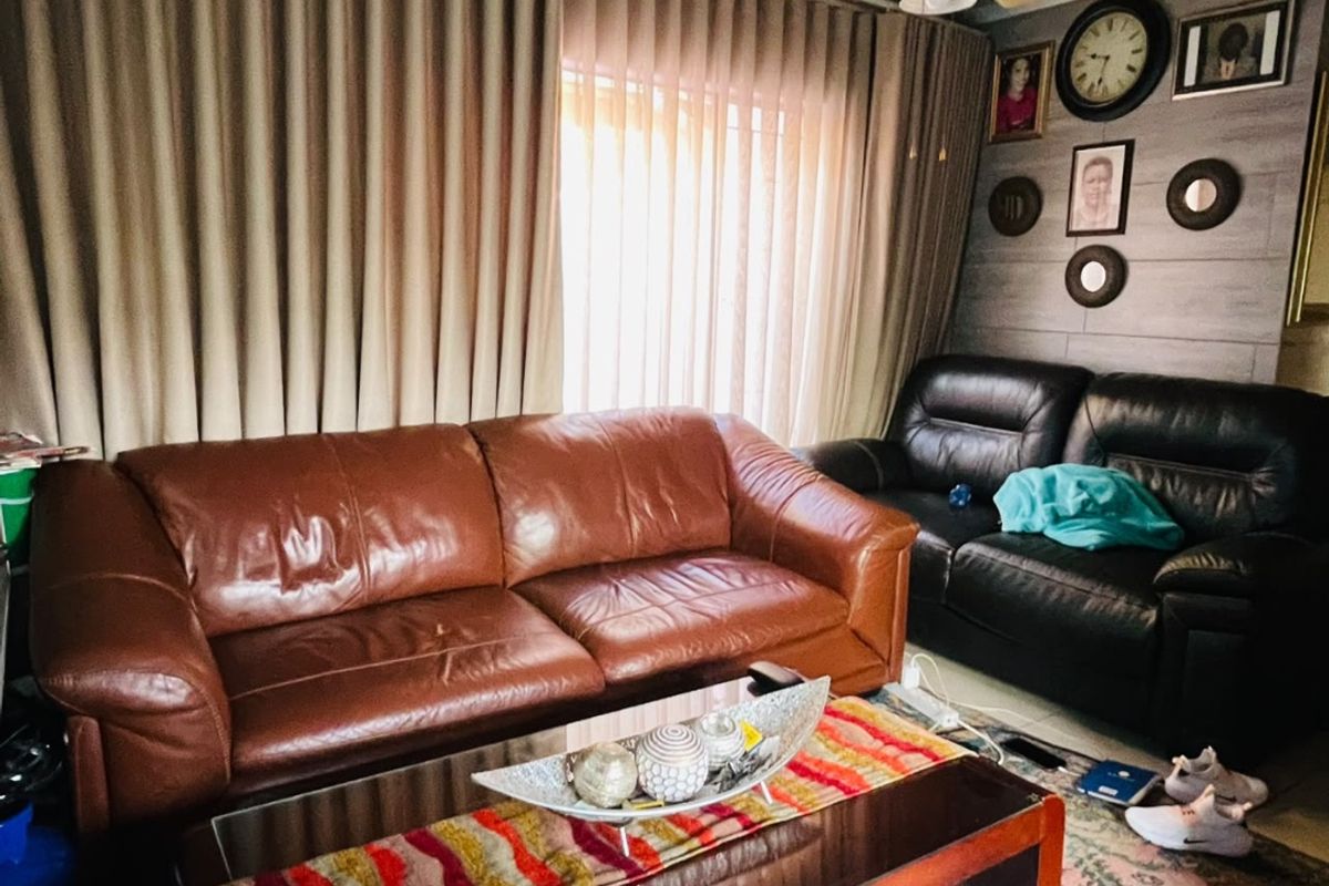 A cozy living room featuring a ceiling fan and wood-look wall paneling, providing a comfortable space for relaxation.