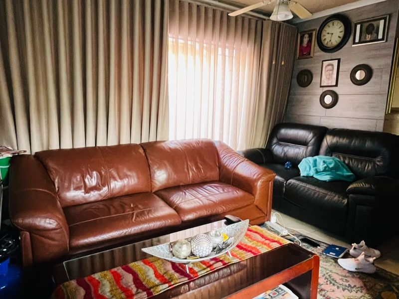 A cozy living room featuring a ceiling fan and wood-look wall paneling, providing a comfortable space for relaxation.