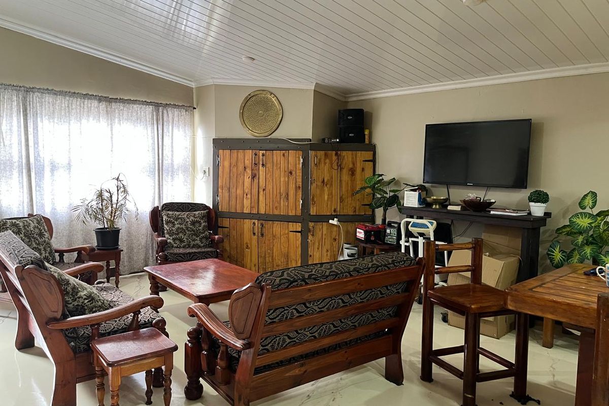 A living room featuring a vaulted tongue and groove ceiling and tiled flooring, providing a spacious area for relaxation.