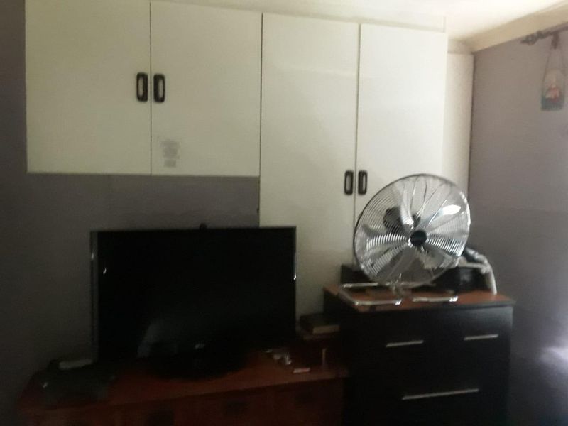 Bedroom featuring built-in storage cabinetry.