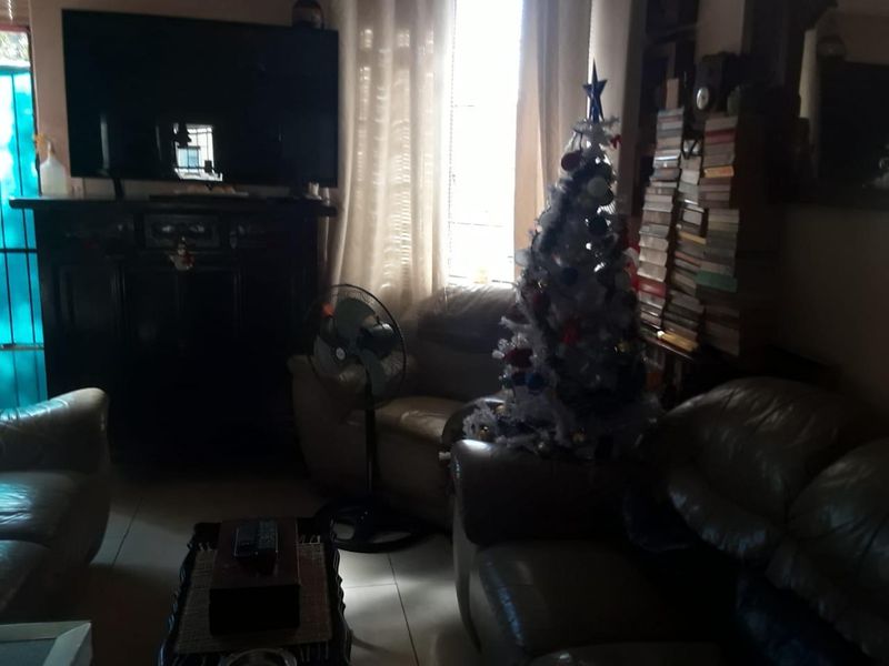 A dimly lit living room featuring tiled flooring and a window, providing a functional space for relaxation.
