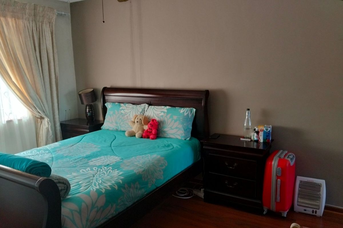 A standard bedroom featuring laminate flooring and a ceiling fan, providing a functional and comfortable living space.