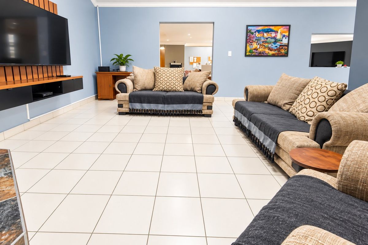 Spacious living room featuring light ceramic tile flooring, blue walls, and a built-in media console unit.