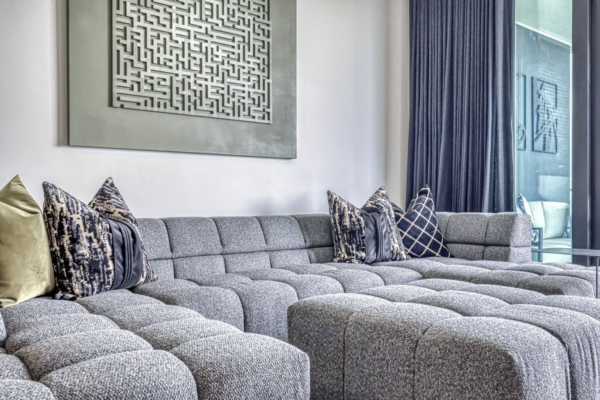 A modern living room featuring floor-to-ceiling curtains and a sliding glass door leading to an outdoor space.