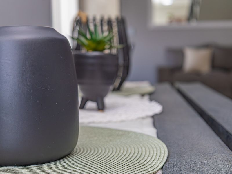 A close-up shot focusing on decorative items on a table, with the living room area blurred in the background.