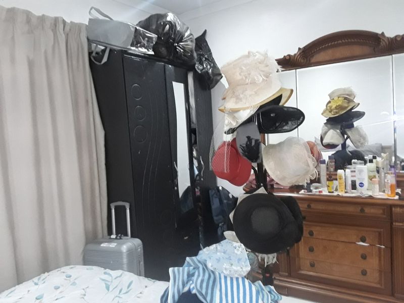 A bedroom featuring a built-in wardrobe and a large vanity mirror, providing functional storage and dressing space.