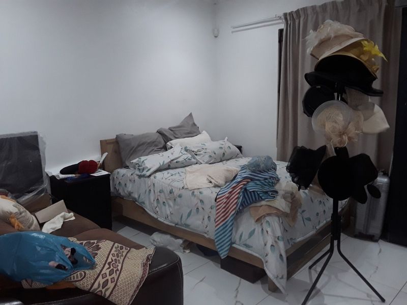 A bedroom featuring tiled flooring and neutral wall finishes, providing a functional space for rest.