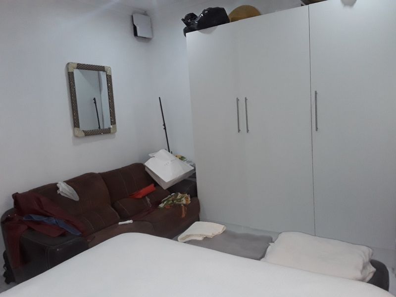 A bedroom featuring a large white built-in wardrobe with modern handles.