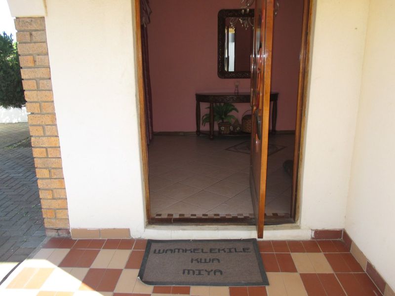 A view of the home entrance featuring a tiled porch area leading into the interior foyer.