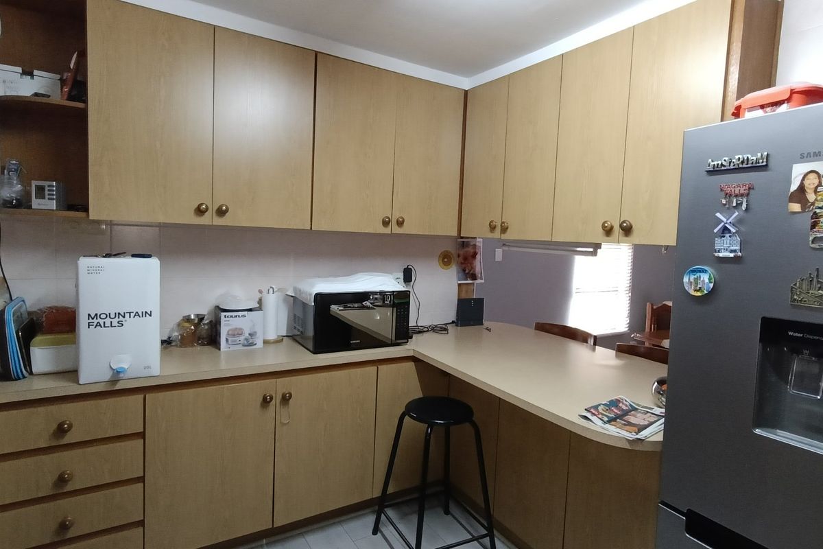 A functional kitchen featuring laminate cabinetry, ample counter space, and a tiled backsplash, offering a practical layout for daily meal preparation.