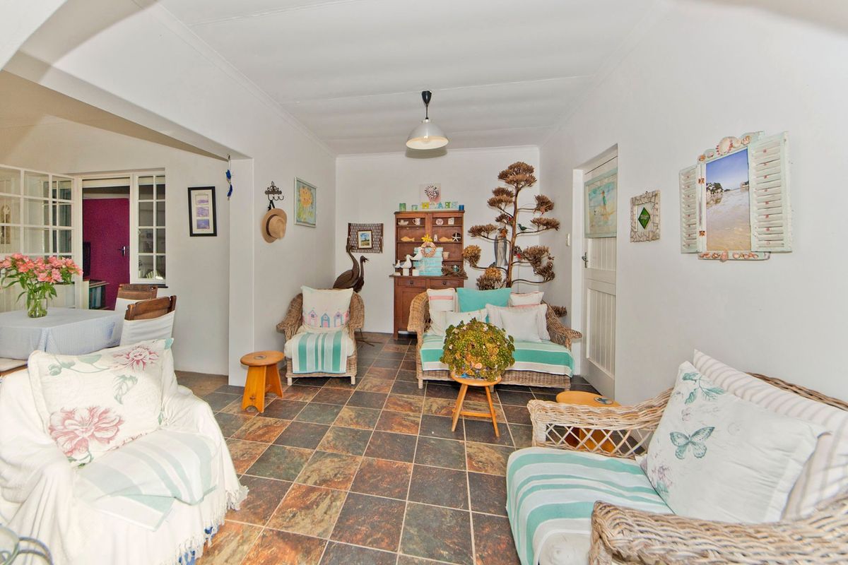 A cozy living room featuring durable tiled flooring and a coved ceiling, with an open-plan layout connecting to the adjacent dining area.