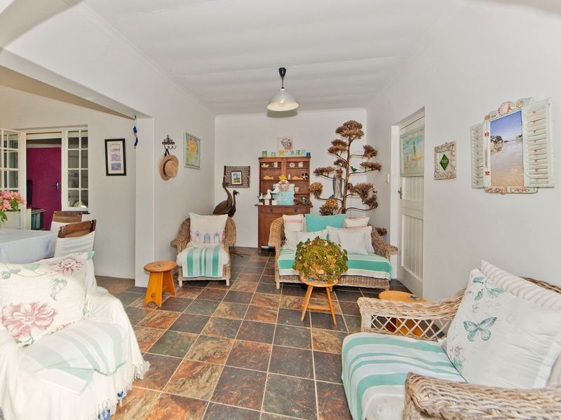 A cozy living room featuring durable tiled flooring and a coved ceiling, with an open-plan layout connecting to the adjacent dining area.