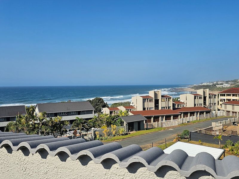 Elevated coastal view overlooking the surrounding residential apartment complex and the ocean horizon.