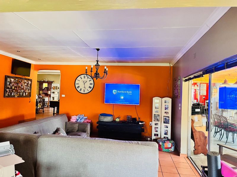 Spacious living room featuring tiled flooring, recessed lighting, and large sliding glass doors providing access to the outdoor area.
