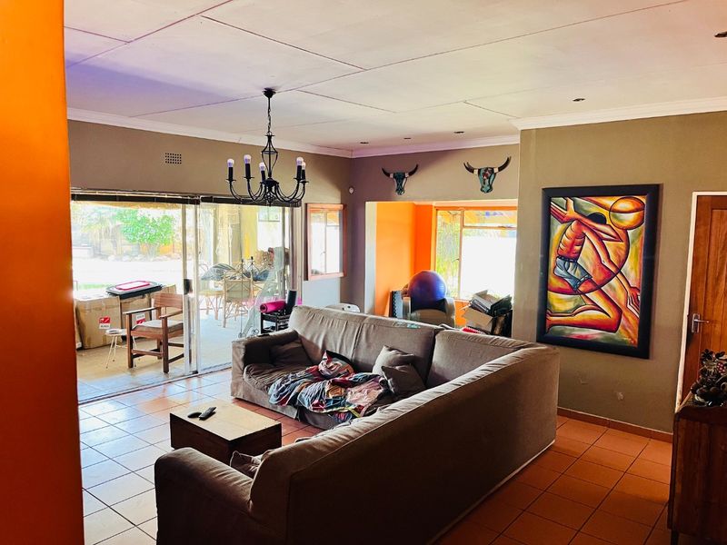 Spacious living room featuring tiled flooring, recessed lighting, and large sliding glass doors providing direct access to the outdoor patio area.
