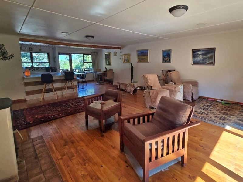 Spacious open-plan living area featuring hardwood flooring, a breakfast bar, and direct access to outdoor space through sliding glass doors.