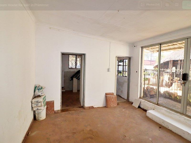 An empty living area featuring concrete flooring, coved ceilings, and a large sliding glass door providing access to the exterior.