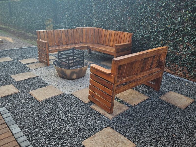 A landscaped rear garden area featuring a gravel base, stone pavers, and a manicured hedge boundary, providing a functional outdoor space.