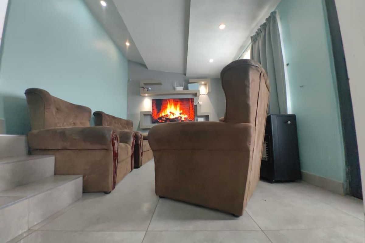A living room featuring tiled flooring, recessed ceiling lighting, and built-in wall shelving units.