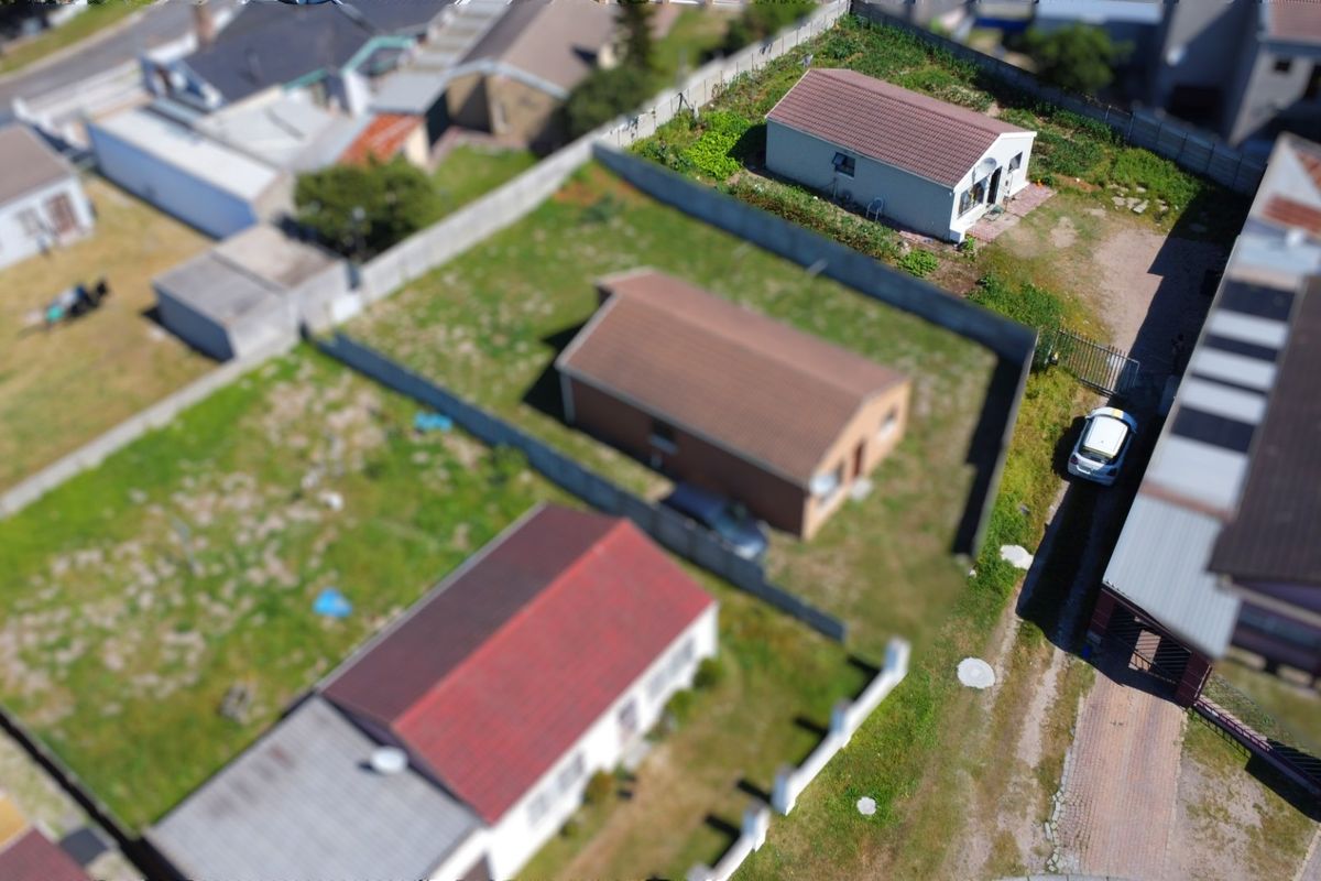 An aerial view of the property showing the residential plot, boundary walls, and surrounding neighborhood layout.