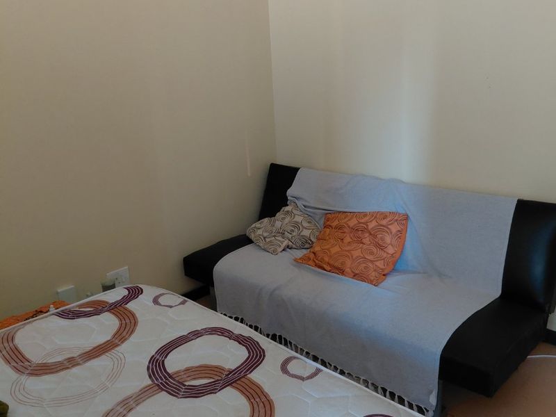 A simple bedroom space featuring neutral walls and standard electrical fixtures, suitable for a variety of bedroom configurations.