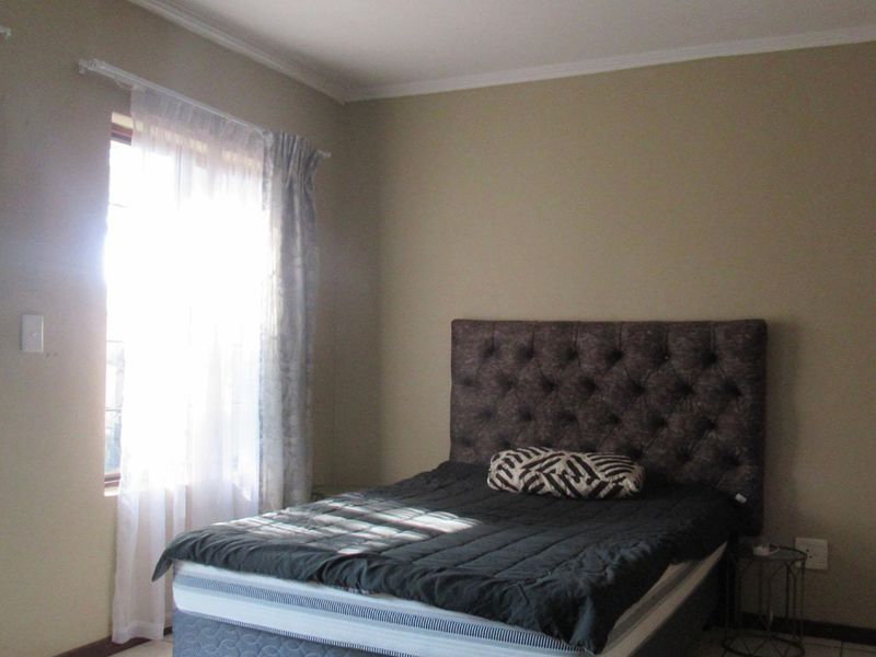 A bedroom featuring tiled flooring, coving, and a sliding door providing access to the exterior.