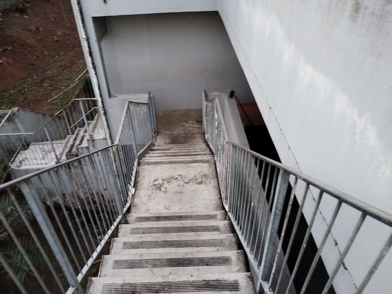 An outdoor concrete staircase with metal railings providing access to the rear of the property.