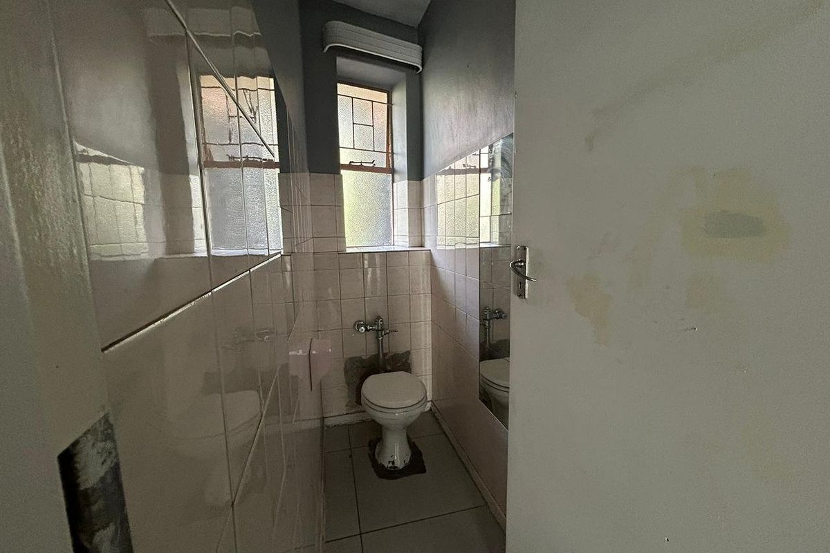 A small, dated bathroom featuring tiled walls and floor, requiring renovation and cosmetic repairs to improve its overall condition and functionality.