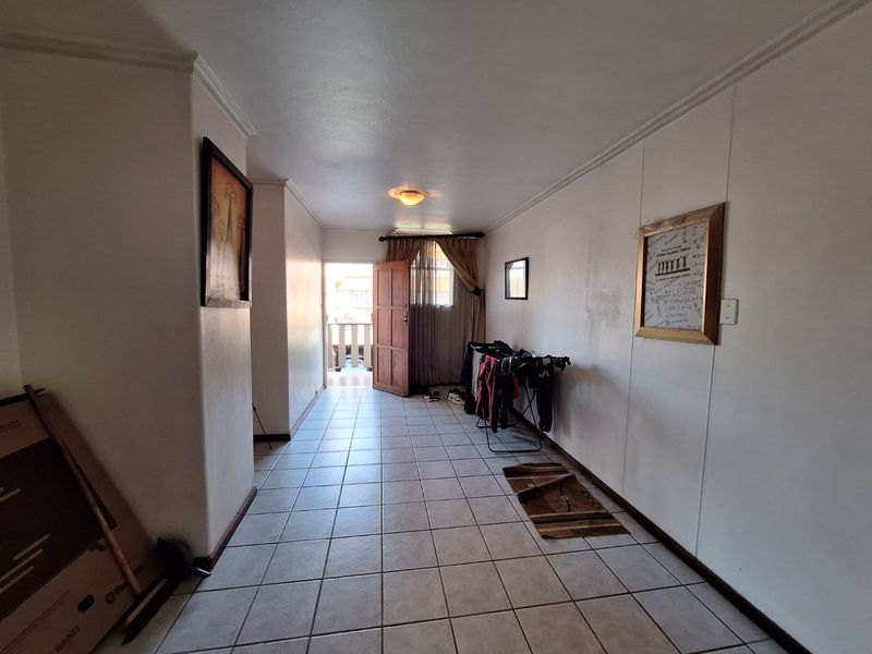 A living area featuring tiled flooring and direct access to an outdoor balcony, providing natural light and a functional layout for living space.