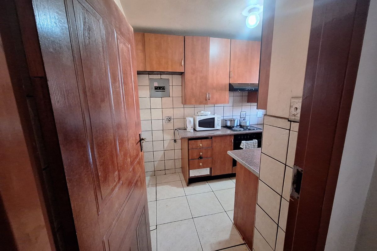 A functional kitchen featuring laminate cabinetry, tiled backsplash, and built-in cooking appliances, offering a practical layout for daily meal preparation.