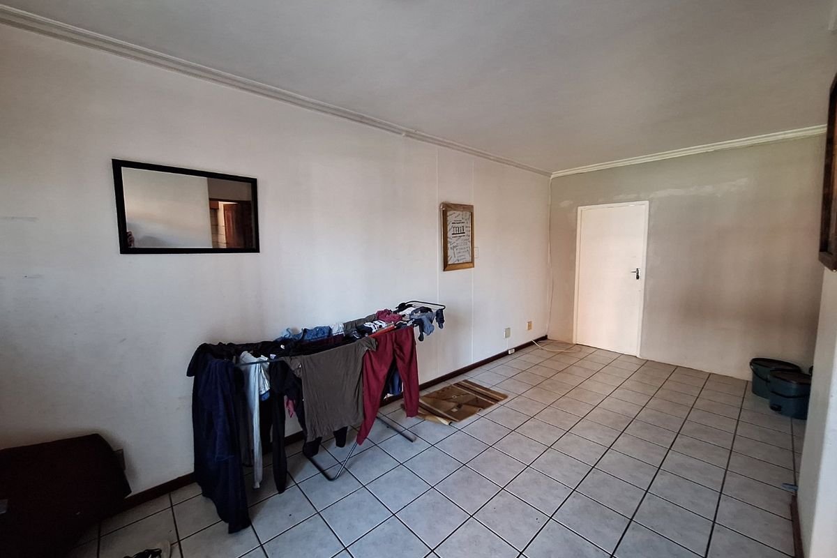 An empty living area featuring tiled flooring and neutral walls, offering a blank canvas for interior design and personalization.