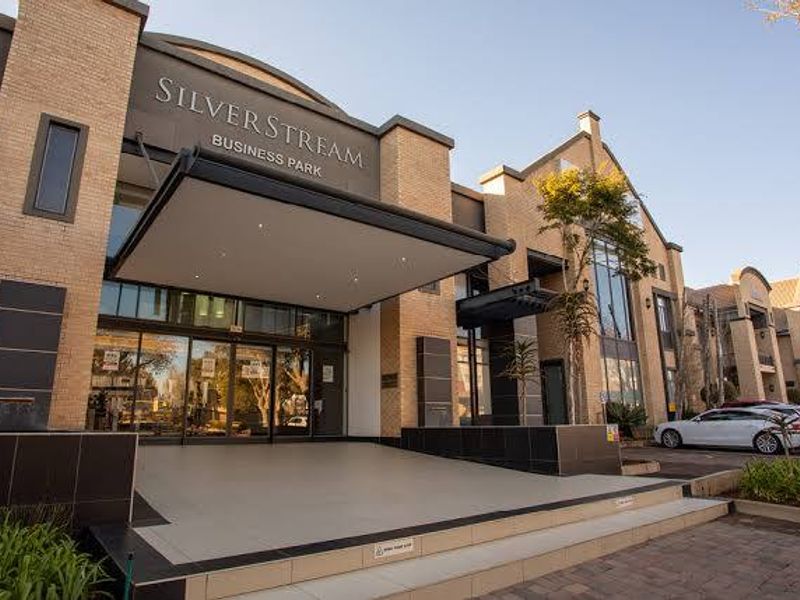 Modern commercial office building entrance at Silverstream Business Park, featuring a prominent canopy, glass facade, and well-maintained brick exterior.