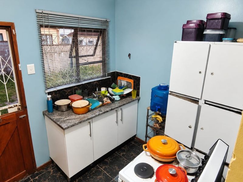 A functional kitchen area featuring base cabinetry, a laminate countertop with a sink, tiled flooring, and an electric stove.