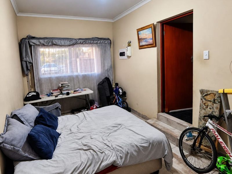 A bedroom featuring tiled flooring and a raised doorway threshold, requiring minor cosmetic updates to improve the overall finish and presentation.