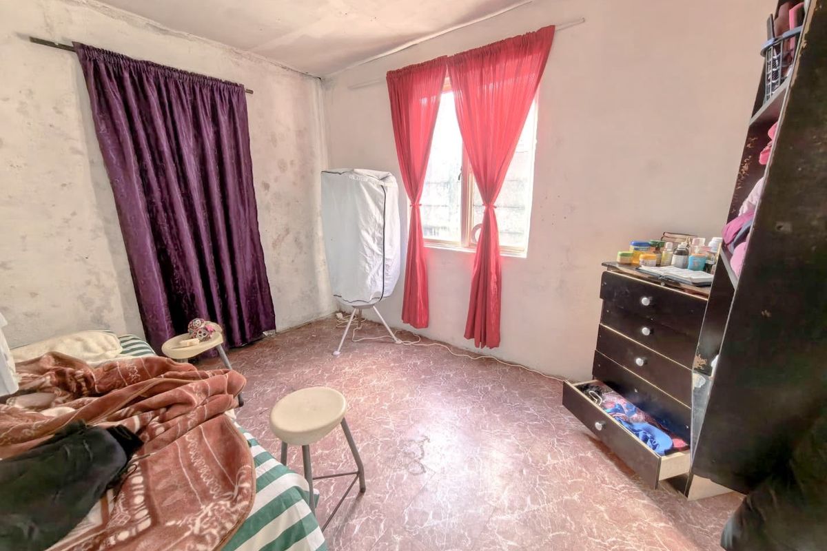 A bedroom featuring basic finishes, including worn flooring and walls in need of maintenance, offering a blank canvas for potential renovation and modernization.