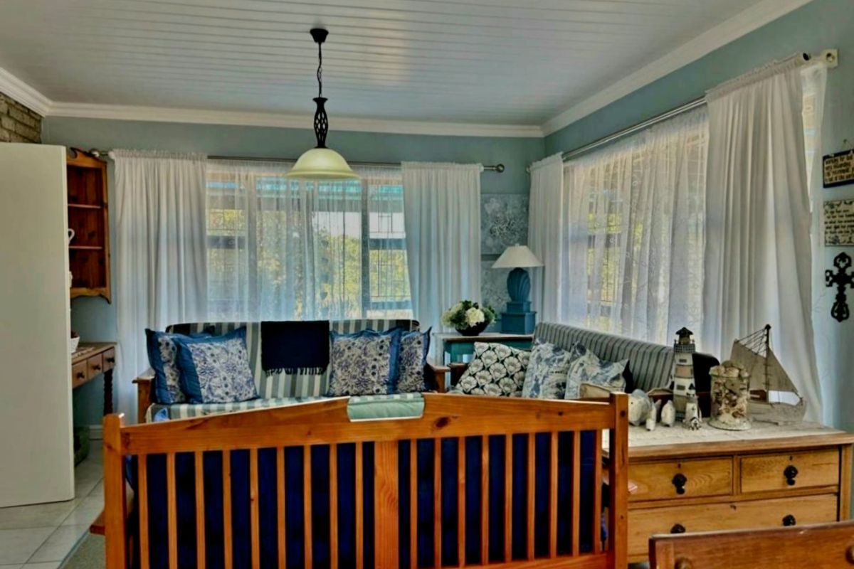 A cozy living room featuring a tongue and groove ceiling, tiled flooring, and large windows that allow for ample natural light.