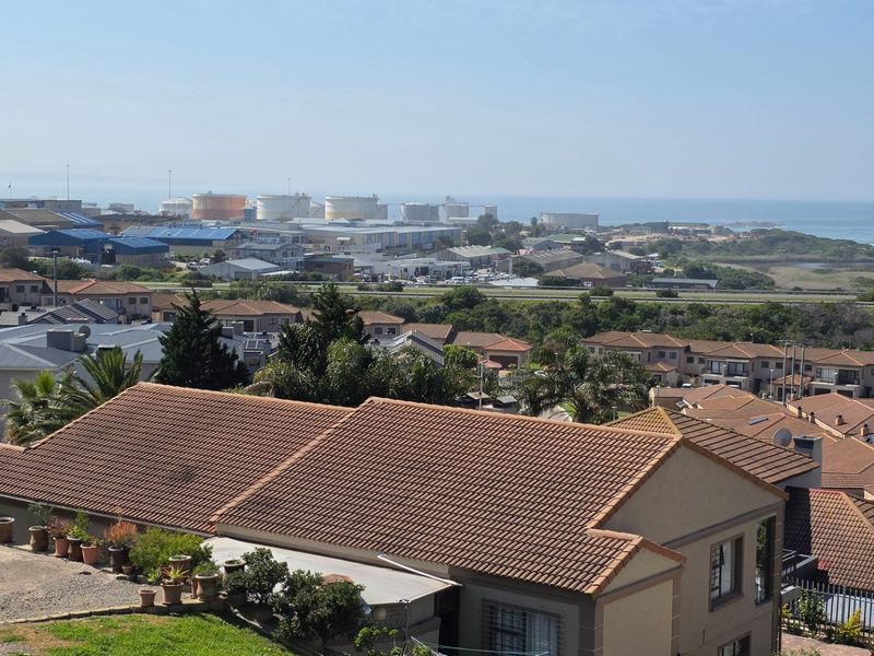 Elevated view overlooking the surrounding residential estate and coastal industrial area, showcasing the property's position within the neighbourhood.