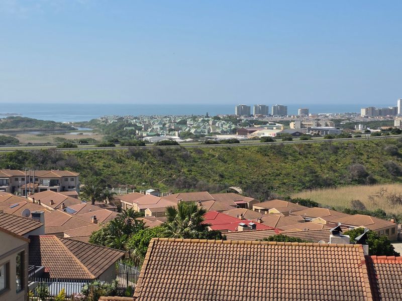 Elevated panoramic view overlooking the surrounding residential neighbourhood, coastal landscape, and distant ocean horizon.