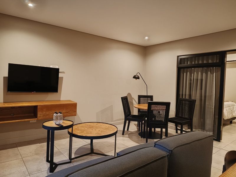 A well-maintained living area featuring tiled floors, recessed lighting, and a wall-mounted cabinet, providing a clean and functional space.