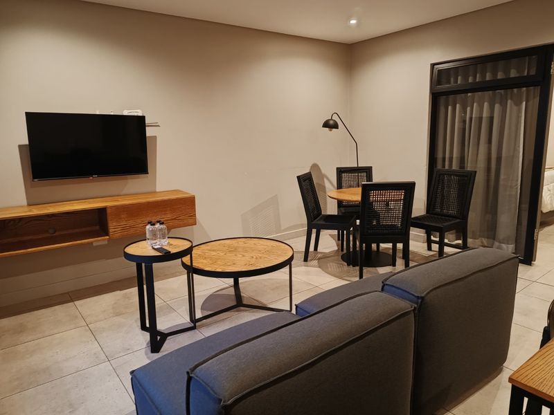 A well-maintained living area featuring neutral tiled flooring, recessed lighting, and a sliding glass door providing access to the exterior.
