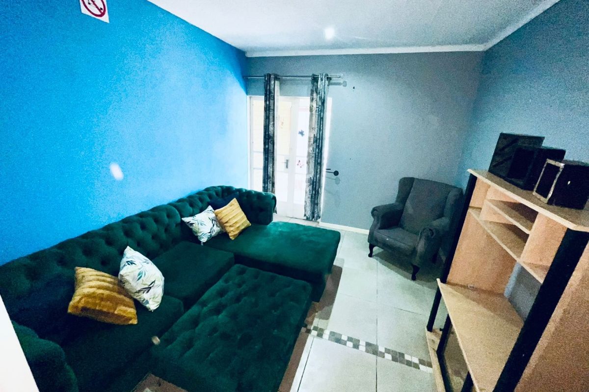 A living room area featuring tiled flooring and access to an exterior door.