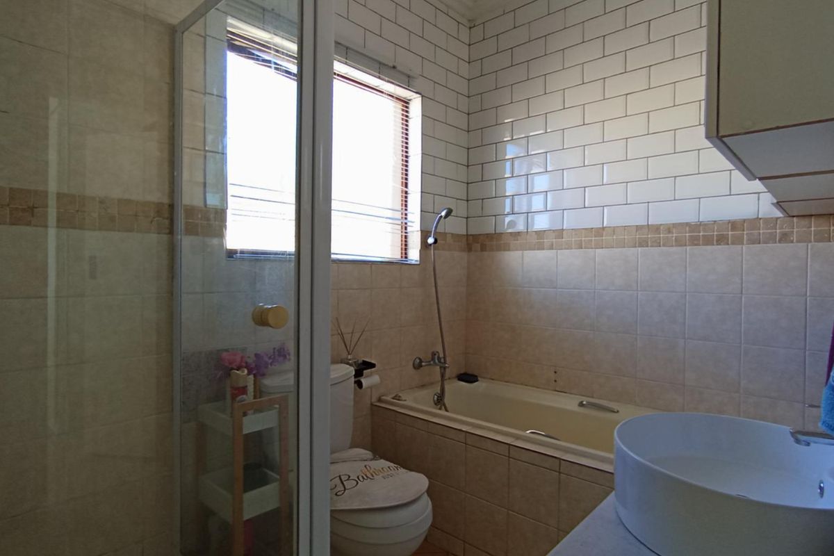 A functional bathroom featuring a glass shower enclosure, a built-in bathtub with subway tile surround, and a modern vessel sink vanity.