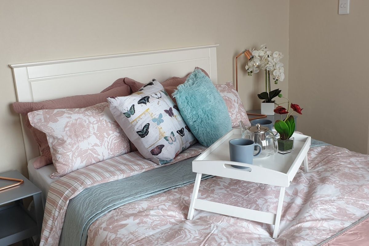 A well-maintained bedroom featuring a neutral color palette and a built-in headboard, creating a comfortable and inviting sleeping space.