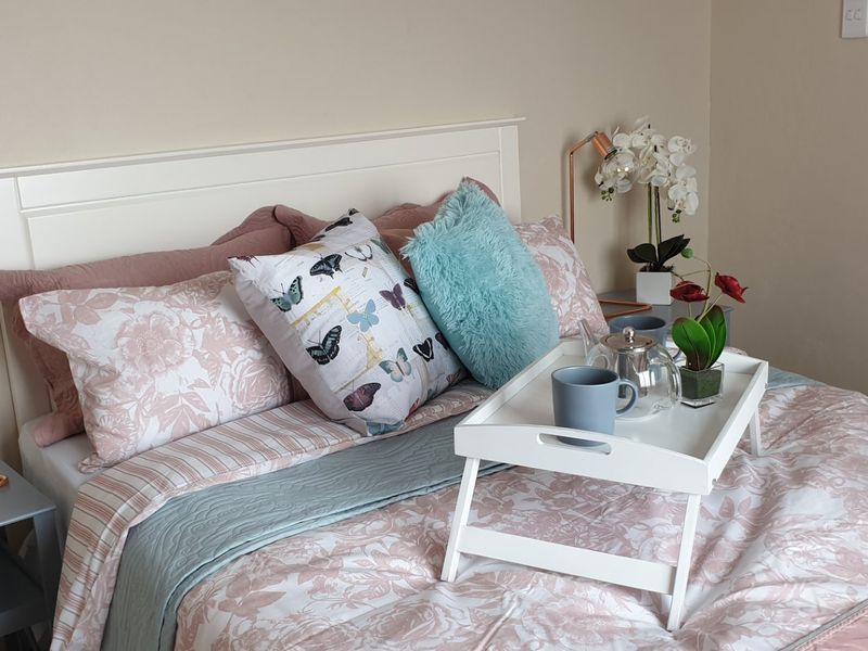 A well-maintained bedroom featuring a neutral color palette and a built-in headboard, creating a comfortable and inviting sleeping space.