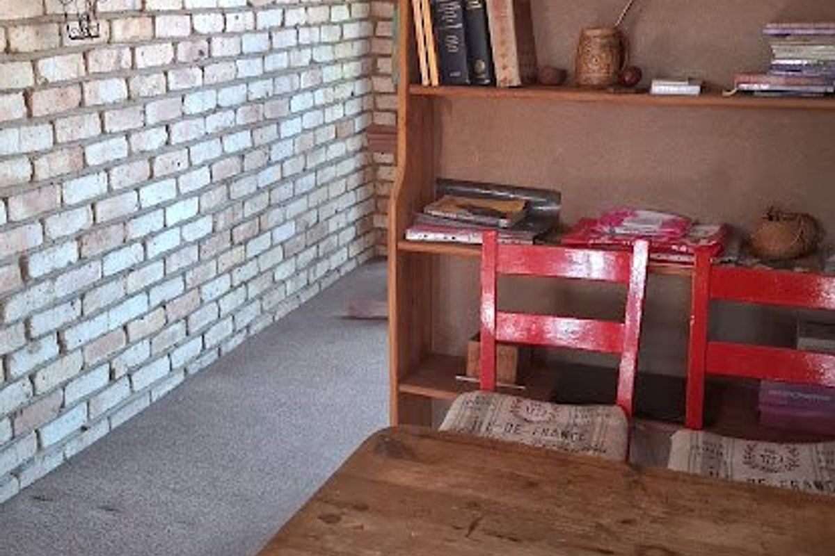 A living area featuring an exposed brick feature wall and coving, providing a rustic aesthetic base for potential interior updates.