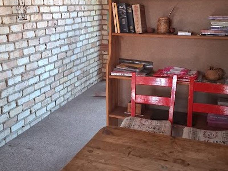 A living area featuring an exposed brick feature wall and coving, providing a rustic aesthetic base for potential interior updates.