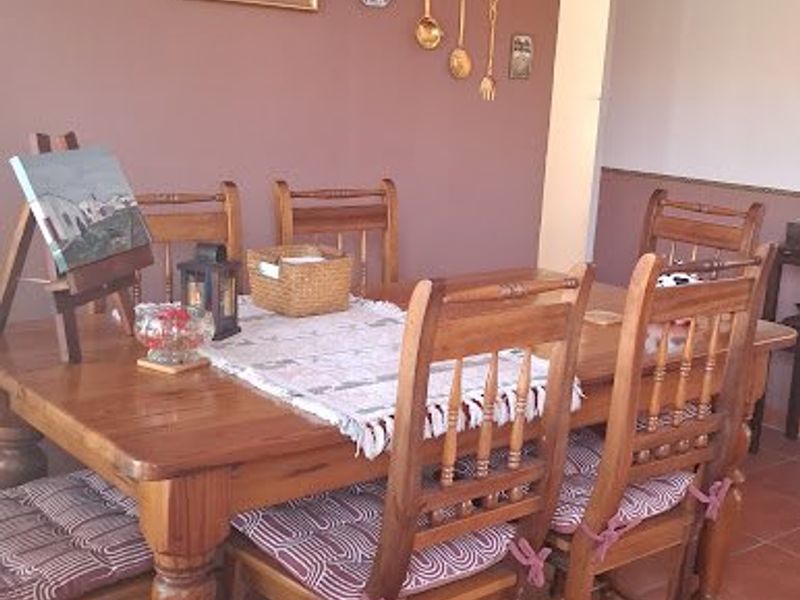 A dining room featuring terracotta floor tiles and neutral wall finishes, providing a functional space for family meals.