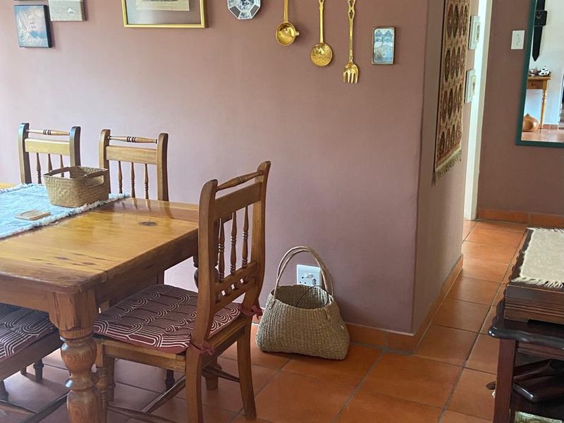 A dining area featuring traditional terracotta floor tiles and a neutral wall finish, providing a functional space for family meals.