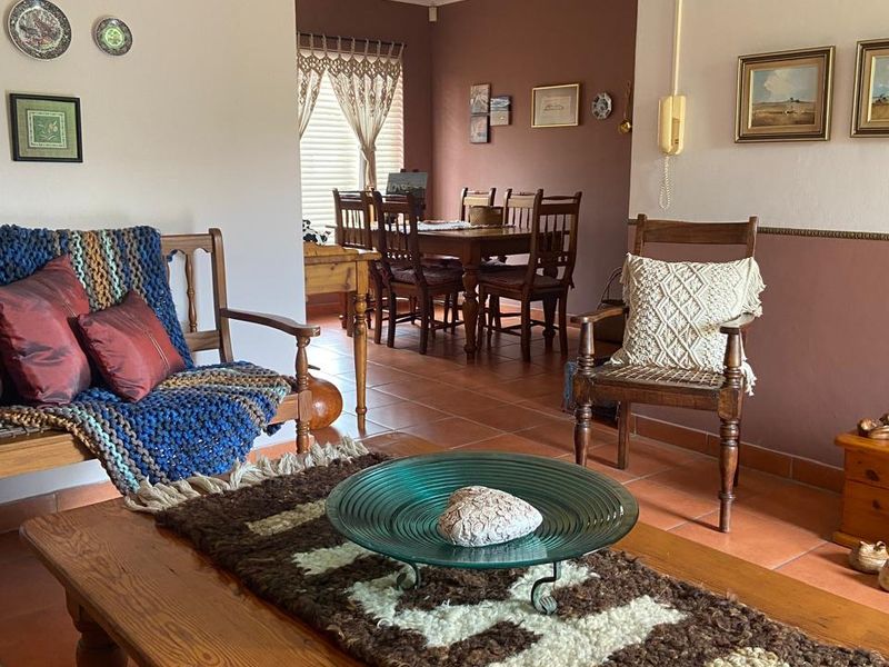 Open-plan living and dining area featuring terracotta floor tiles and neutral wall tones, providing a functional and connected layout for daily living.