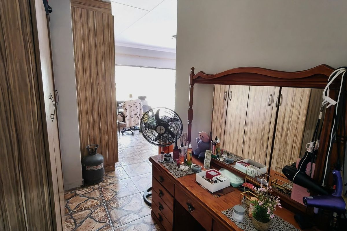 Bedroom featuring built-in wooden cupboards and tiled flooring, providing functional storage space within the home.